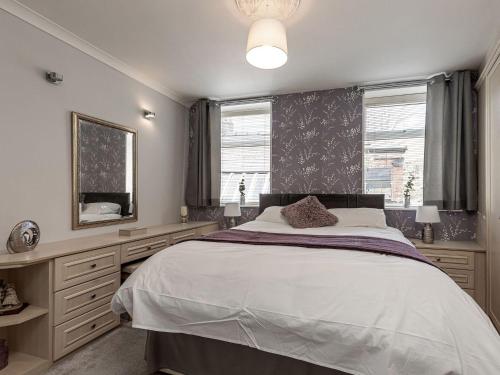 Un dormitorio con una cama grande y un espejo. en The Crows Nest, en Buxton