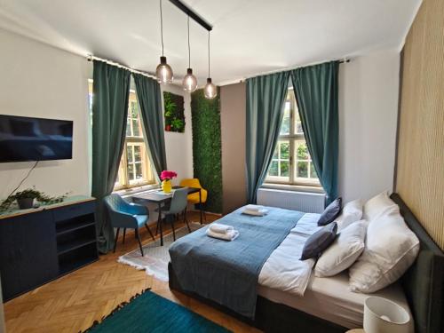a bedroom with a bed and a desk and a television at Vila Mezi Časy in Trutnov