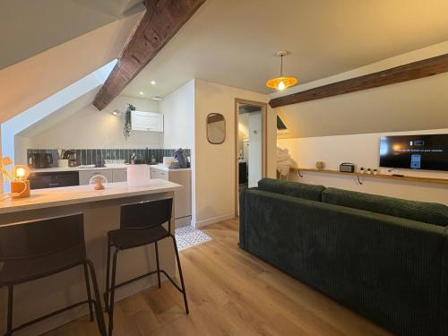 un salon avec un canapé et un bar avec un comptoir dans l'établissement Le puits du bourg, à Nevers