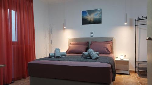 a bedroom with a large bed with two pillows at SpoonLand in Néa Koútali