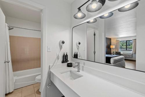 a white bathroom with a sink and a mirror at Adventure Inn Durango in Durango