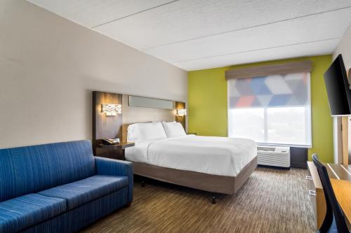 a hotel room with a bed and a couch at Holiday Inn Express & Suites Jacksonville South East - Medical Center Area by IHG in Jacksonville