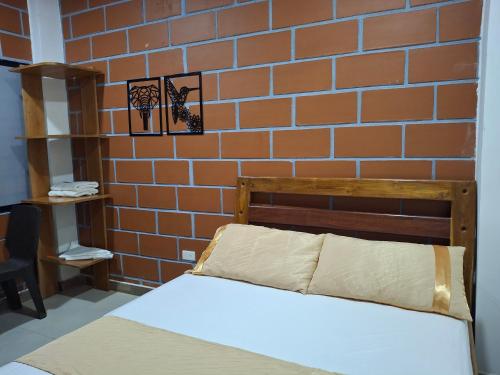 a bed in a room with a brick wall at Hotel Cabañas Mar Caribe in Necoclí