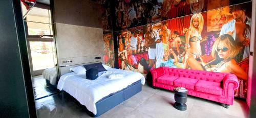 une chambre avec un canapé rose et une grande fresque murale dans l'établissement Village Naturiste Cap d'Agde 224 Résidence de luxe Les jardins d'Eden 