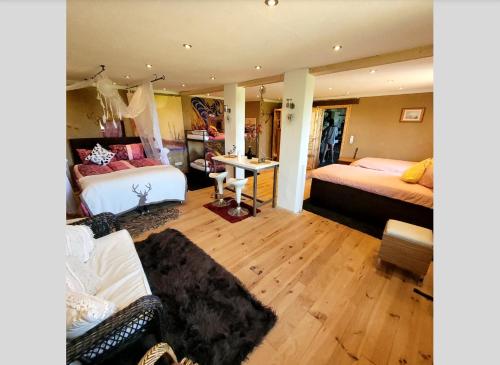 a bedroom with two beds and a desk in it at Studio Pachamama in Rotenburg an der Wümme