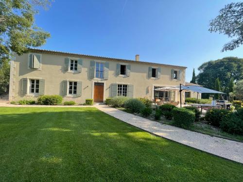 une grande maison avec une pelouse devant dans l'établissement Mas de Nanor, à Saint-Rémy-de-Provence