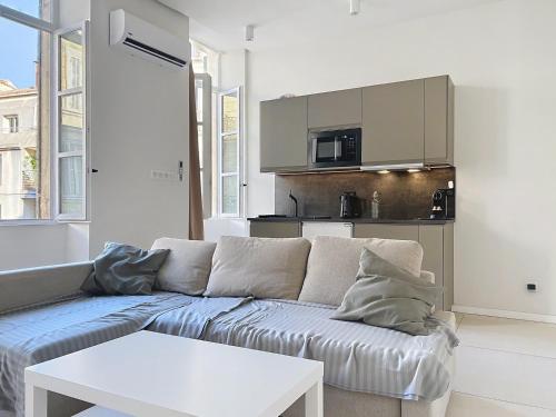un salon avec un canapé et une cuisine dans l'établissement Climatisé,Comfort & Design in Marseille, Confort & style à Marseille, à Marseille