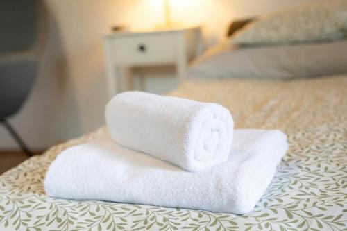 a stack of towels sitting on top of a bed at Tisch Vendégház in Hajdúszoboszló