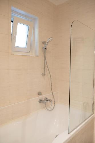 a bathroom with a shower and a bath tub at Tisch Vendégház in Hajdúszoboszló