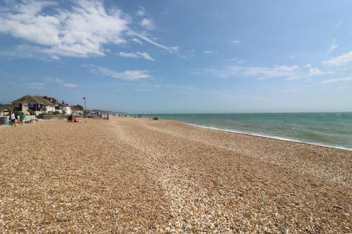 a beach with people on it and the ocean at Flat 4 - Penthouse in Hythe