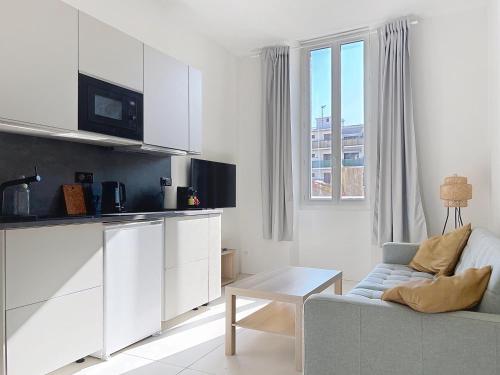 un salon blanc avec un canapé et une table dans l'établissement Cosy climatisé Quartier Endoume, à Marseille