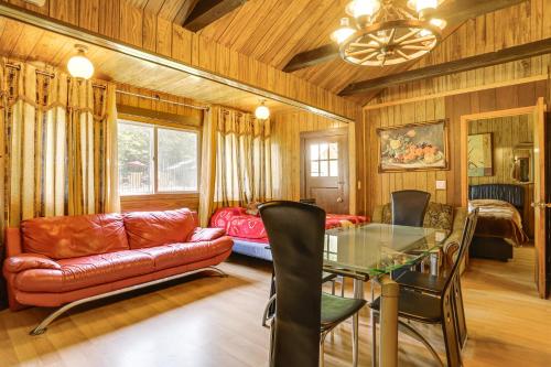 Mongaup ValleyにあるCommunity Perks Mongaup Valley Cabin with Grill!のソファとガラスのテーブルのあるリビングルーム