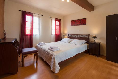 a bedroom with a bed and two windows with red curtains at The old town Neighbourhood in Rhodes Town