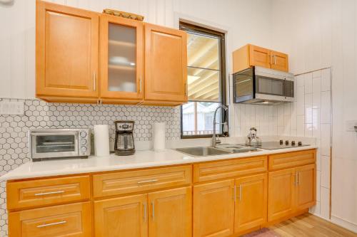 a kitchen with wooden cabinets and a sink and a microwave at 6 Mi to State Park Mongaup Valley Cabin! in Mongaup Valley