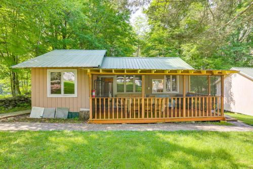 Mongaup Valleyにある5 Mi to Monticello Raceway Cabin Near Shopsの小屋(ベランダ、緑の屋根付)