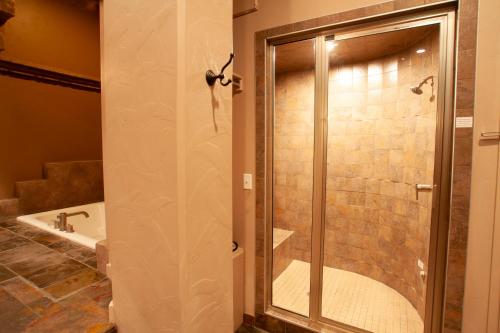 a shower with a glass door in a bathroom at Destinations Inn Theme Rooms in Idaho Falls