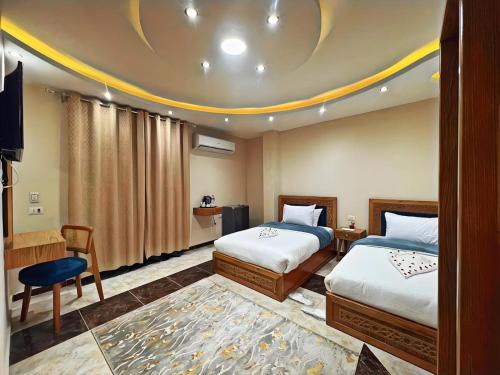 a hotel room with two beds and a tv at The Pyramids Crypt Inn in Cairo