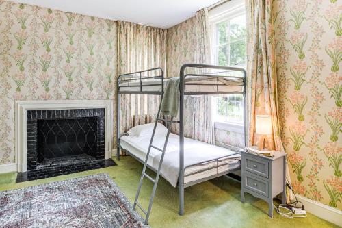 a bedroom with two bunk beds and a fireplace at 16 Mi to Baltimore Spacious Home in Owings Mills! in Owings Mills