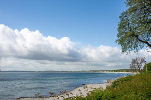 - une vue sur la plage et l'océan par une journée nuageuse dans l'établissement Seehof, à Sierksdorf