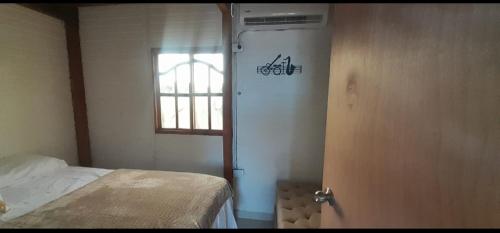 a room with a bed and a door with a window at Cabaña Barbacoas in Santa Ana