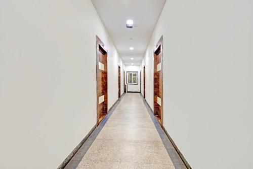 a hallway with white walls and a long corridor at Super Collection O Vizag International Cricket Stadium in Visakhapatnam