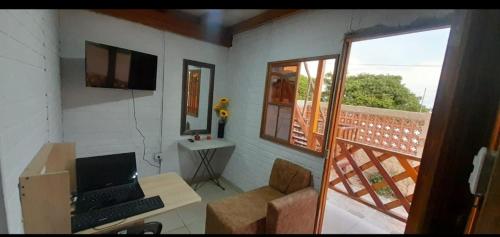 a living room with a laptop computer on a desk at Cabaña Barbacoas in Santa Ana