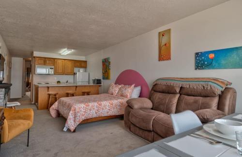 a bedroom with a couch and a bed and a kitchen at Sea Gypsy Rentals - Oceanfront Suite - Top Floor in Lincoln City
