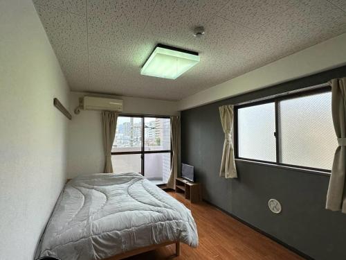 a bedroom with a bed and two windows at Hare no hi Hakushima - Vacation STAY 94989v in Hiroshima