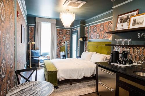 a hotel room with a bed and a desk and chair at The Gas Lamp Hotel in Philadelphia
