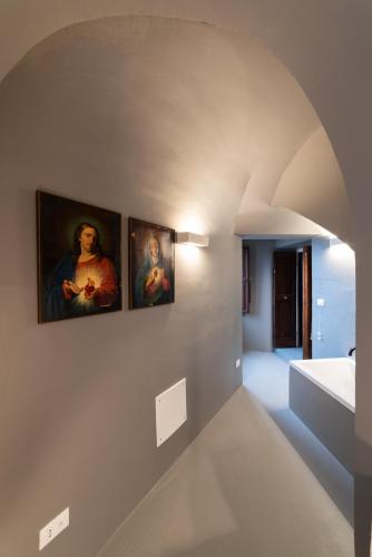 a hallway with three paintings on the wall at Palazzo D'Alessandro Wunderkammer & Suites B&B di charme in Caporciano