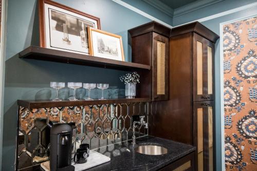 a kitchen with a sink and a shelf with a coffee maker at The Gas Lamp Hotel in Philadelphia