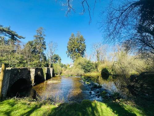 a bridge over a river in a park at Cobblers Walk - Luxury Country Getaway 