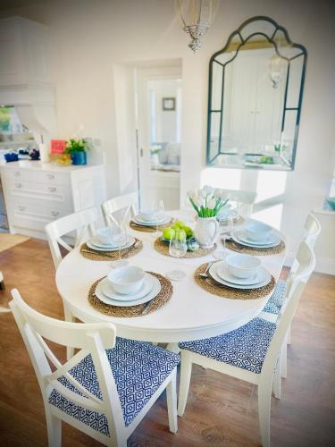 a white dining room table with four chairs and a white tableablish at Cobblers Walk - Luxury Country Getaway 