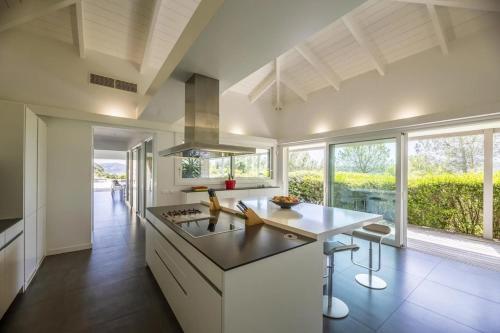 Il comprend une cuisine équipée d'une cuisinière et d'une grande fenêtre. dans l'établissement Beautiful home in Vico, à Vico