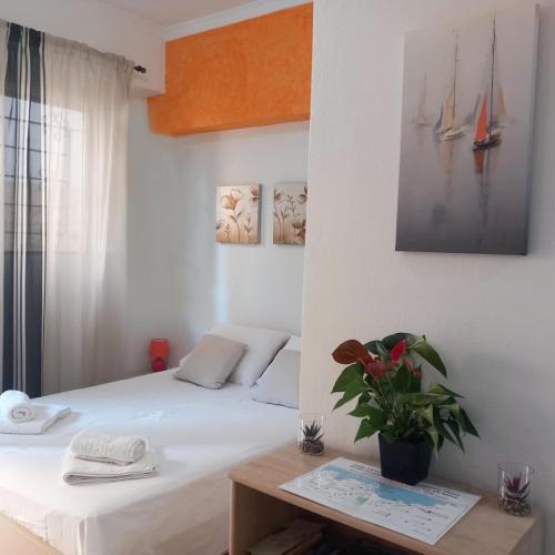 a bedroom with a bed and a table with a potted plant at Studio Victory Chania in Chania