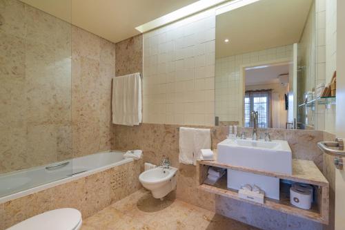 a bathroom with a tub and a toilet and a sink at Vilamoura Marina Lake in Vilamoura