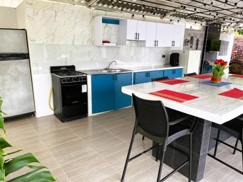 a kitchen with blue cabinets and a white counter top at Divina Finca Nueva llegando a Villeta para 6 a 8 in Nocaima