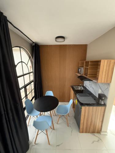 a kitchen with a table and blue chairs in a room at Caza mia in Acolman de Netzahualcóyotl