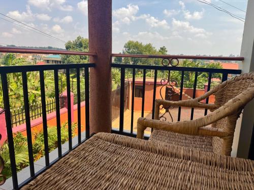 a balcony with a chair and a view of a playground at Kampala Comfort 1 in Nalakonge
