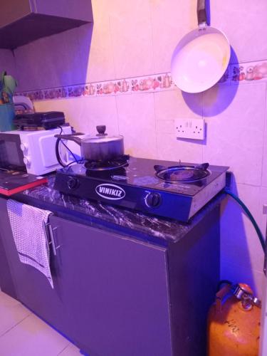 a kitchen with a stove with a pot on it at His Royal Glamour Apartments in Lagos