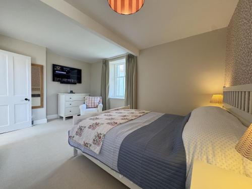 a bedroom with a bed and a chair and a television at Crab Shack, Crail in Crail