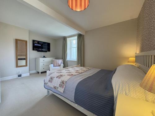 a bedroom with a bed and a chair and a television at Crab Shack, Crail in Crail