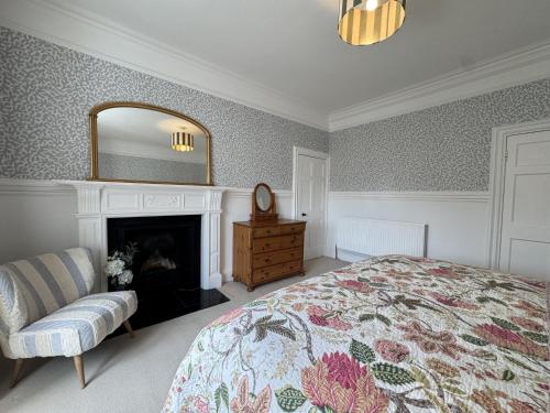 a bedroom with a bed and a fireplace and a mirror at Crab Shack, Crail in Crail