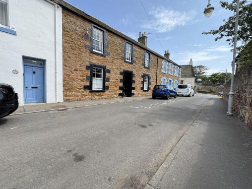an empty street with cars parked on the side of a building at Crab Shack, Crail in Crail