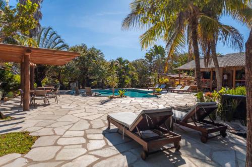 a patio with lounge chairs and a swimming pool at Pousada Flores do Cerrado in Pirenópolis