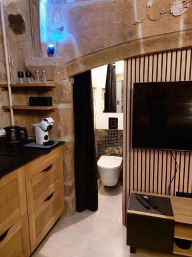 La salle de bains est pourvue d'une télévision et de toilettes. dans l'établissement La parenthèse Ponote - Hammam - WIFI - city center, au Puy-en-Velay
