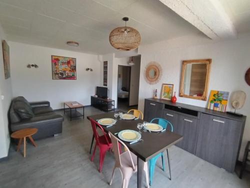 un salon avec une table, des chaises et un canapé dans l'établissement Bas de villa, terrasse au calme, à Gattières