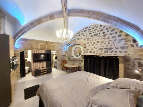 une chambre avec un lit et un mur en pierre dans l'établissement La parenthèse Ponote - Hammam - WIFI - city center, au Puy-en-Velay