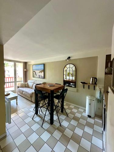 un salon avec une table et un canapé dans l'établissement Les Jardins d'Opale 1, à Le Touquet-Paris-Plage