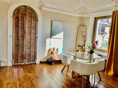 une salle à manger avec une table en verre et des chaises blanches dans l'établissement Old town, experience out of time, à Nice